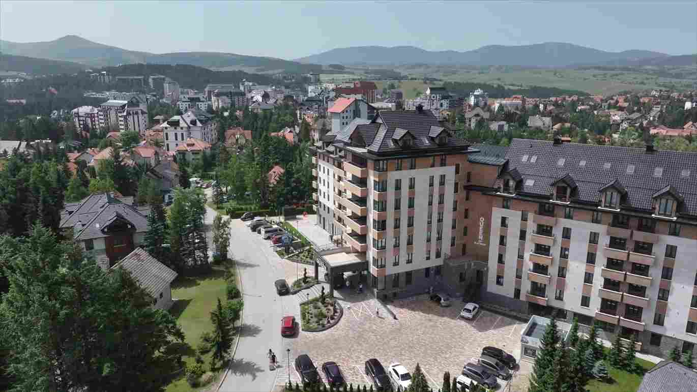Moderan hotelski kompleks na Zlatiboru okružen zelenilom i planinskim pejzažom